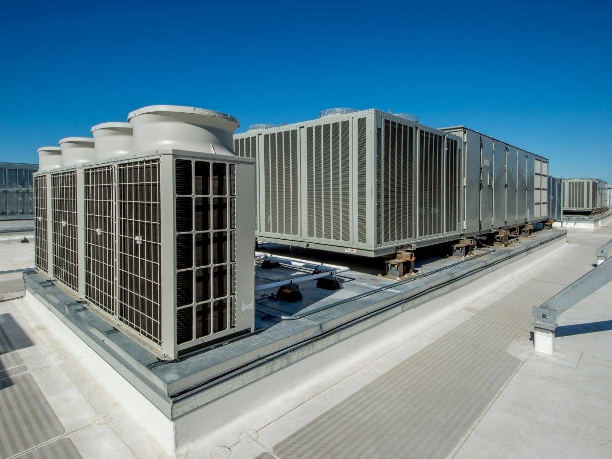 Commercial heat pump condensers and rooftop units on a building roof