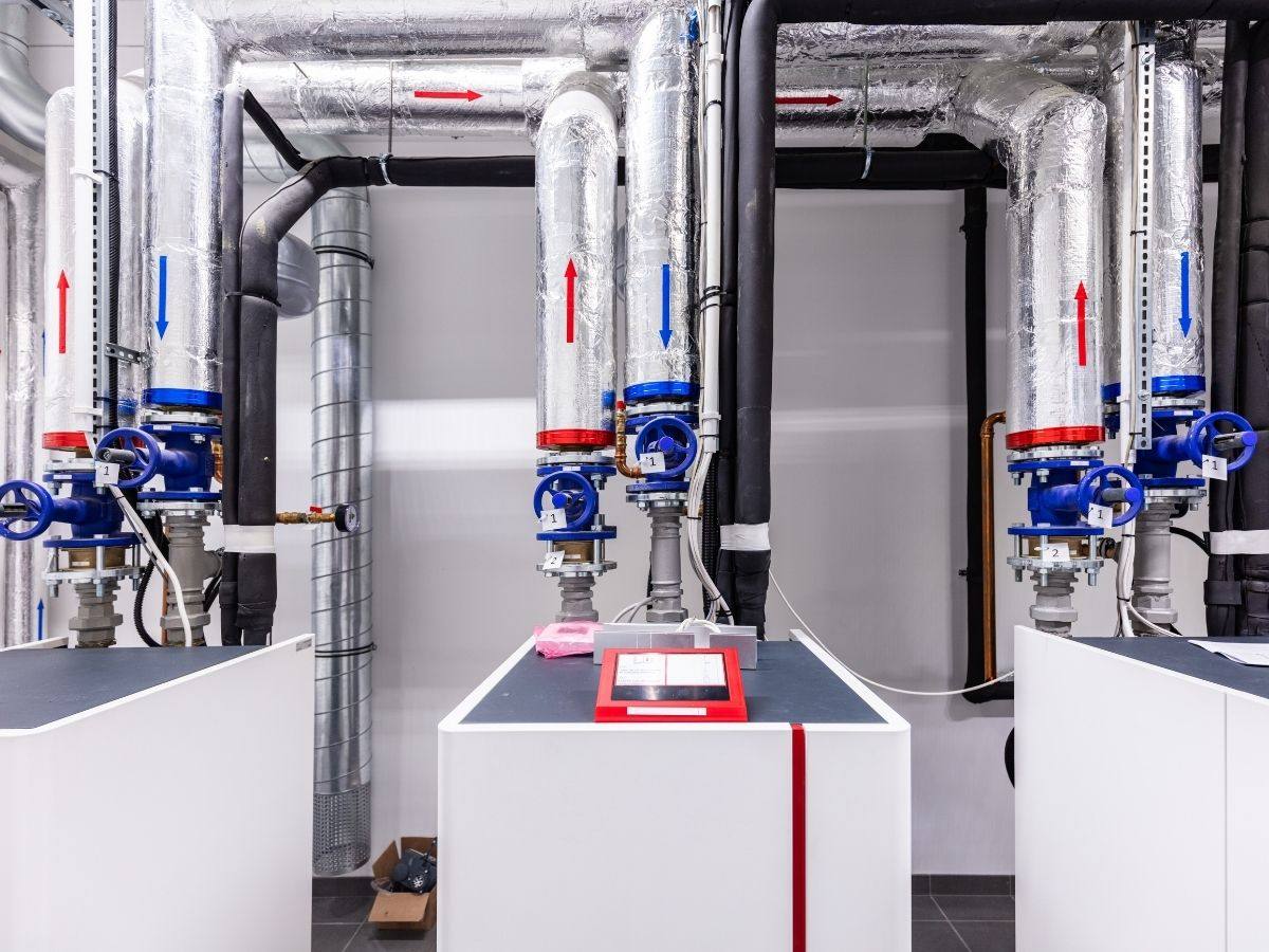 Commercial heating system pipes and valves in a building mechanical room