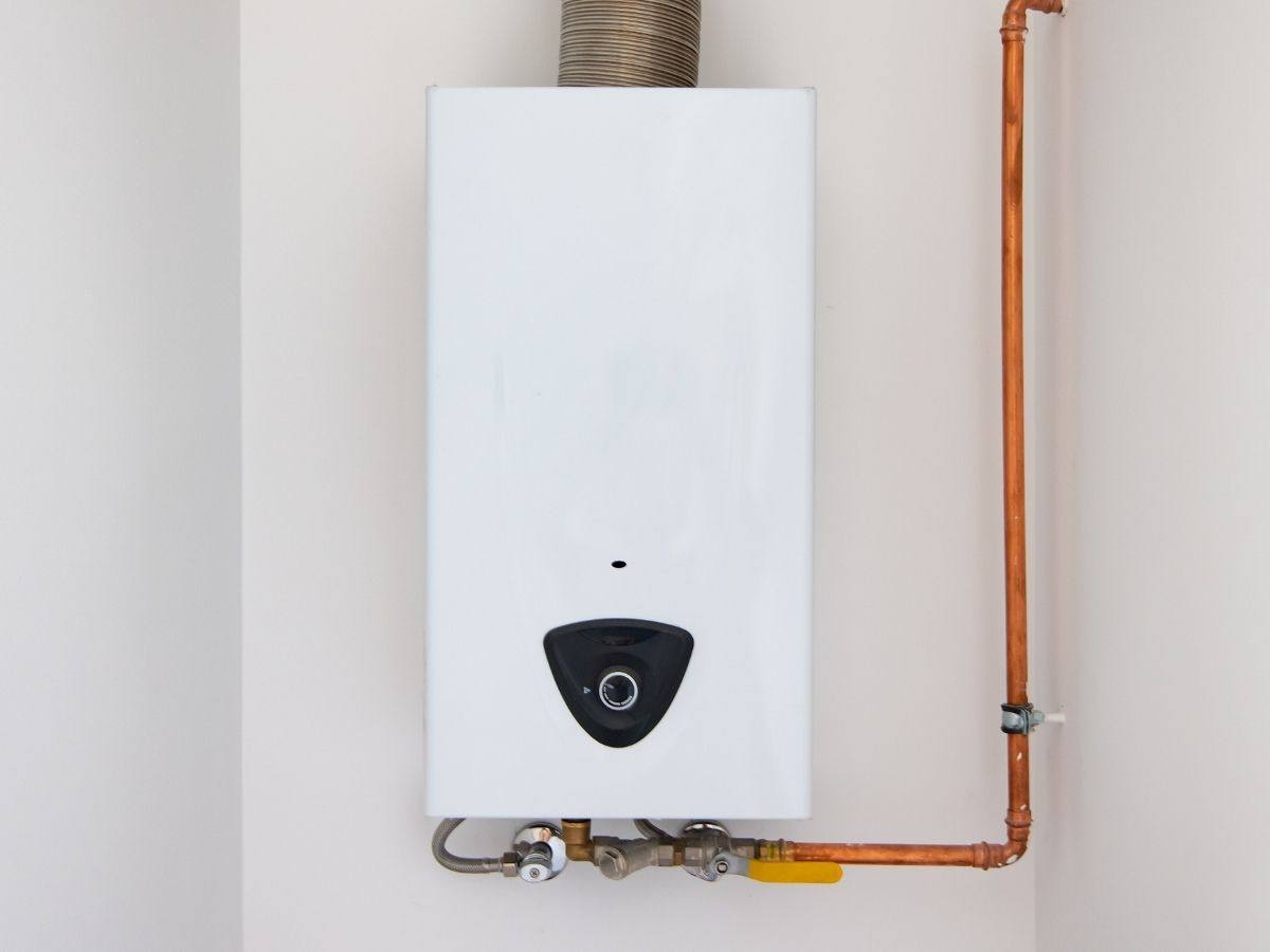 Tankless water heater installed on a wall with a copper gas line